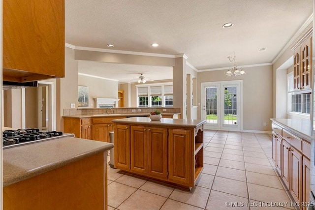 8531 S 70th E Ave, Tulsa, OK 74133 - kitchen with light tile patterned flooring, stainless steel gas cooktop, crown molding, a chandelier, and recessed lighting