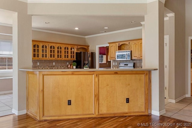 8531 S 70th E Ave, Tulsa, OK 74133 - kitchen featuring appliances with stainless steel finishes, glass insert cabinets, decorative backsplash, ornamental molding, and a peninsula
