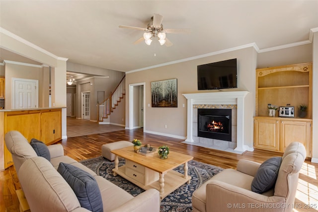 8531 S 70th E Ave, Tulsa, OK 74133 - living room with ceiling fan, wood finished floors, a tile fireplace, crown molding, and baseboards