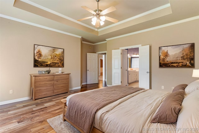 8531 S 70th E Ave, Tulsa, OK 74133 - bedroom featuring a tray ceiling, light wood-style floors, baseboards, ornamental molding, and ensuite bath