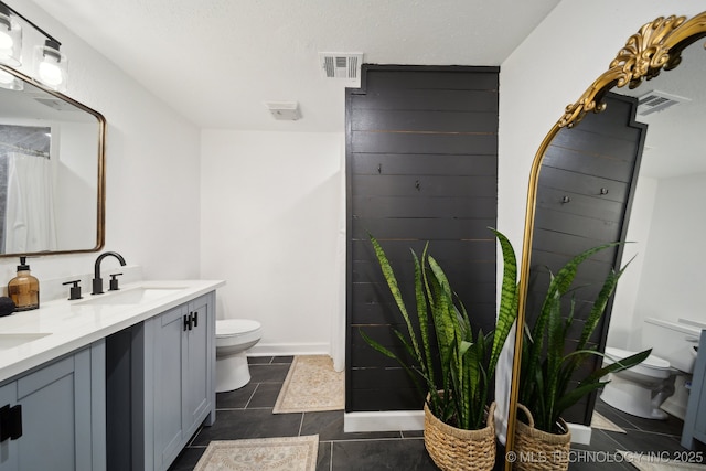 full bathroom featuring toilet, double vanity, tile patterned floors, and a shower with curtain