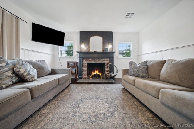 living area featuring a fireplace, healthy amount of natural light, and wood finished floors