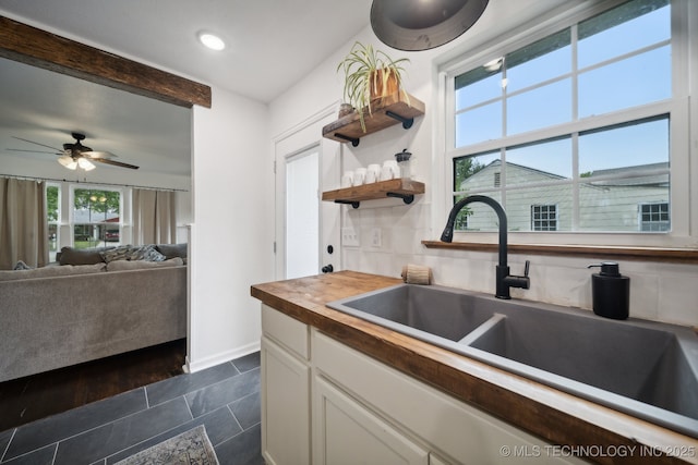 kitchen featuring butcher block counters, a sink, white cabinets, a ceiling fan, and recessed lighting