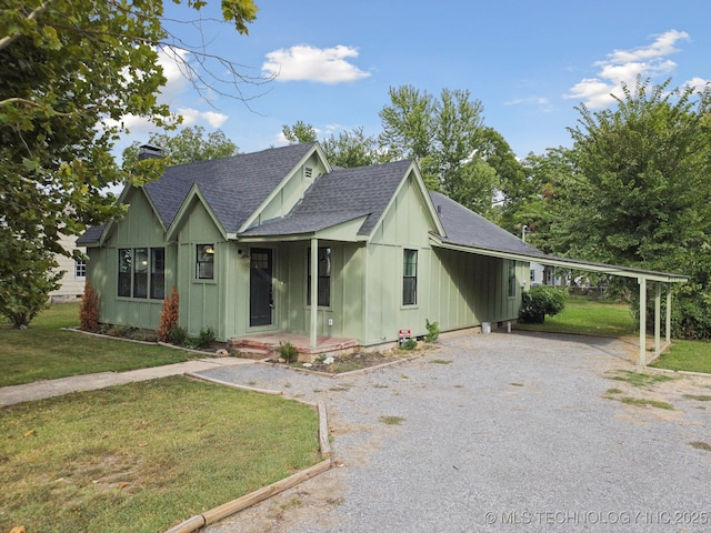 view of front of property featuring driveway, a shingled roof, board and batten siding, a front lawn, and a porch