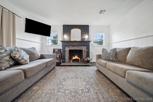 living area featuring a fireplace, healthy amount of natural light, and wood finished floors