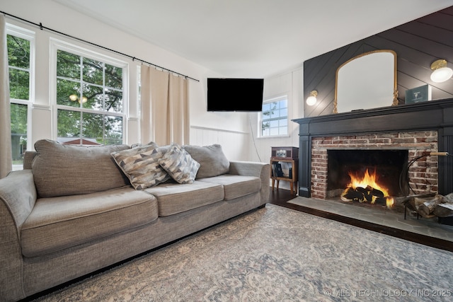 living area with a brick fireplace and a decorative wall