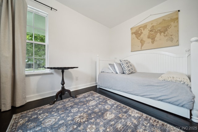 bedroom featuring vaulted ceiling, wood finished floors, and baseboards