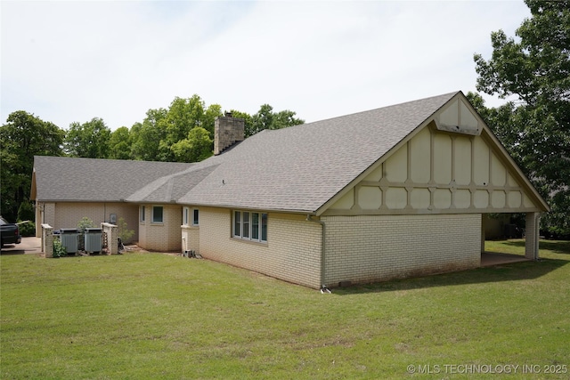 5941 E 87th St, Tulsa, OK 74133 - rear view of house featuring board and batten siding, a lawn, a chimney, and brick siding