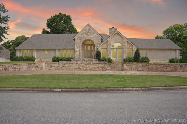 5941 E 87th St, Tulsa, OK 74133 - french provincial home with stone siding, a chimney, and a yard