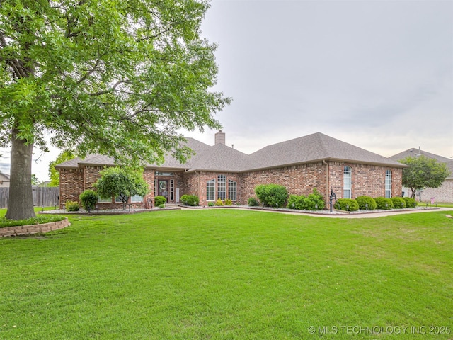 ranch-style house featuring brick siding, a chimney, and roof with shingles
