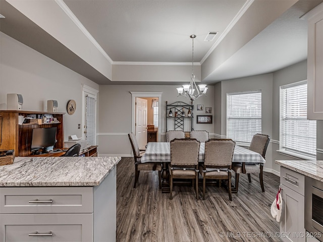 dining room with dark wood-style flooring, a chandelier, crown molding, and baseboards