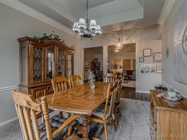 dining room featuring decorative columns, a chandelier, baseboards, dark wood-style floors, and ornamental molding