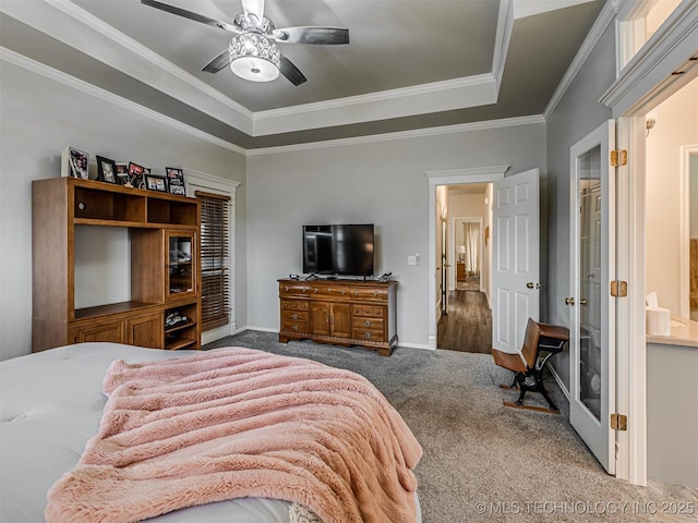 bedroom with carpet flooring, a tray ceiling, ornamental molding, baseboards, and a ceiling fan