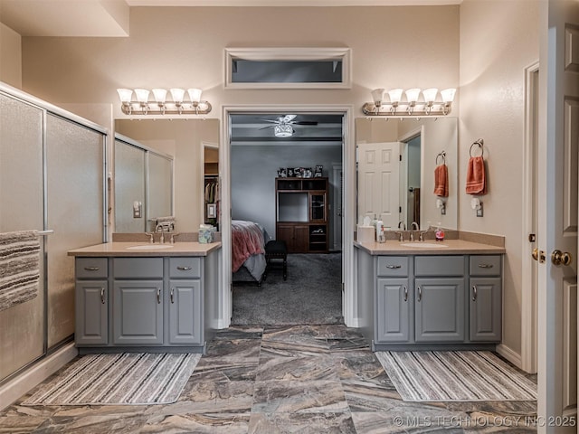 ensuite bathroom with marble look tile flooring, a stall shower, and two vanities