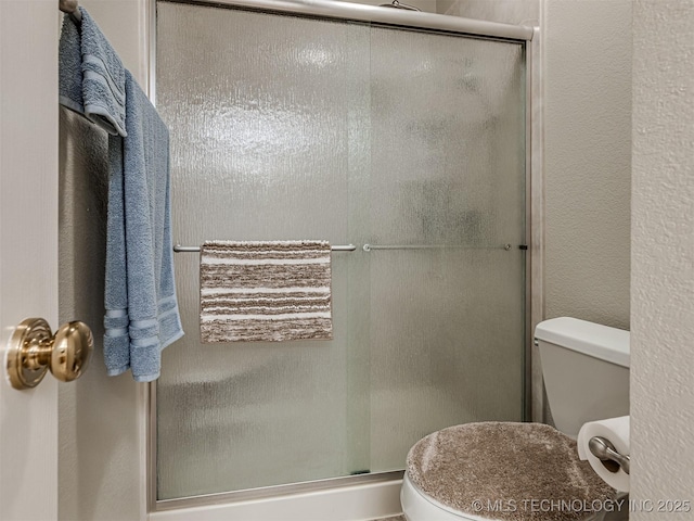 full bath with a shower stall and toilet