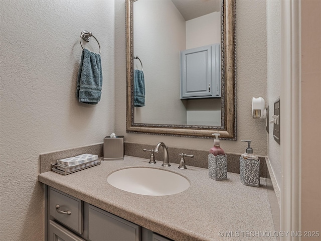 bathroom featuring a textured wall and vanity