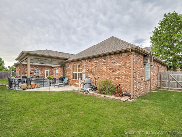 back of property featuring brick siding, a patio area, and a shingled roof