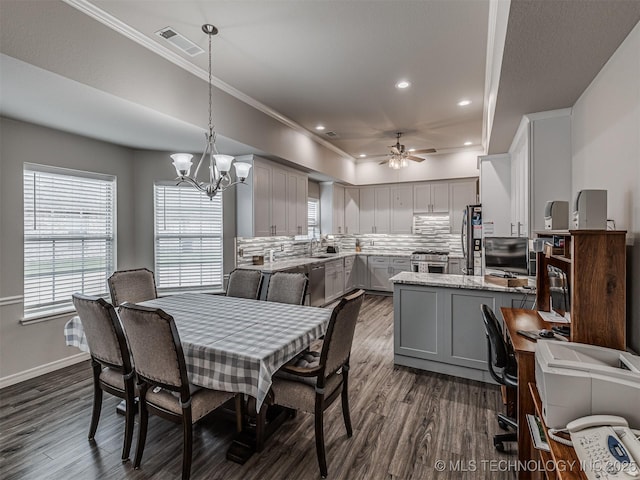 dining room featuring dark wood-style floors, crown molding, a ceiling fan, a chandelier, and recessed lighting