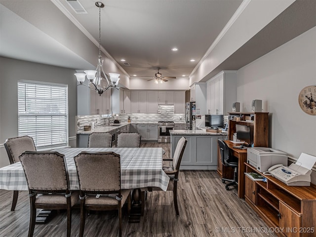dining space with a ceiling fan, dark wood-style flooring, a chandelier, recessed lighting, and crown molding