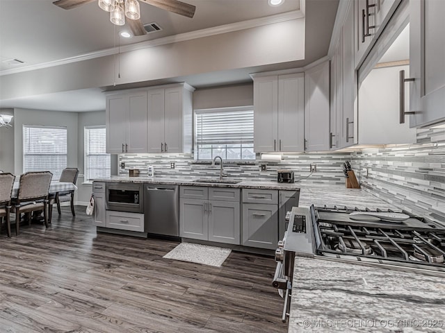 kitchen featuring a sink, stainless steel appliances, ceiling fan, gray cabinets, and crown molding