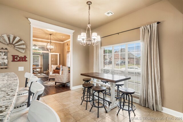 dining space with a chandelier, baseboards, and ornamental molding