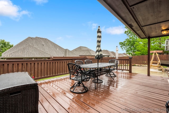 wooden deck featuring outdoor dining space and a fenced backyard