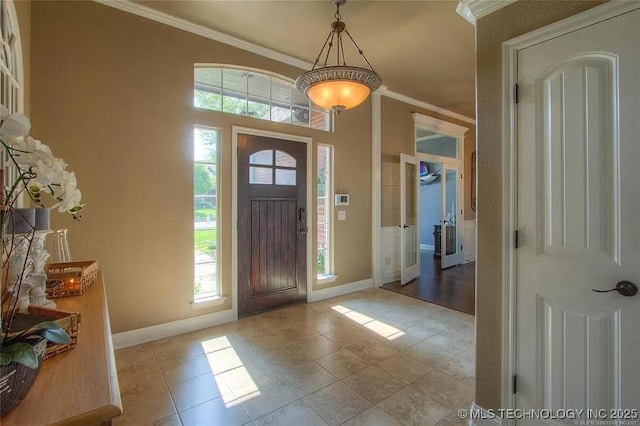 foyer entrance featuring ornamental molding, baseboards, healthy amount of natural light, and tile patterned flooring