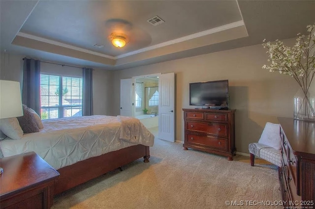 carpeted bedroom featuring a raised ceiling, ensuite bath, crown molding, and baseboards