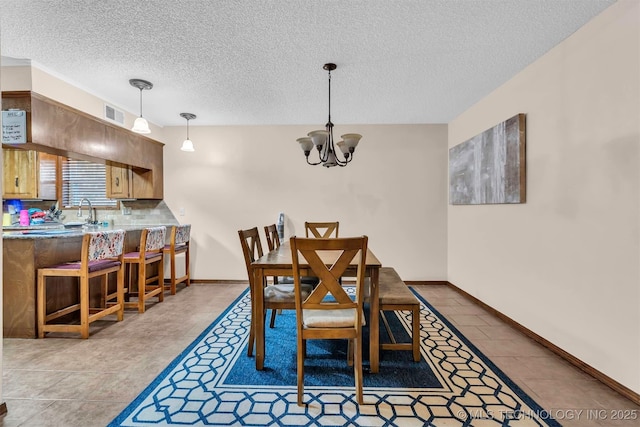 1205 Beaverly, Ardmore, OK 73401 - dining room featuring a textured ceiling, a chandelier, and tile patterned floors