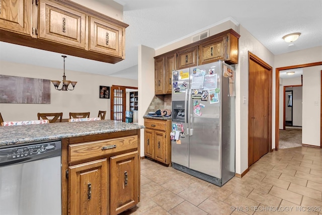 1205 Beaverly, Ardmore, OK 73401 - kitchen featuring appliances with stainless steel finishes, a chandelier, brown cabinetry, baseboards, and light tile patterned flooring