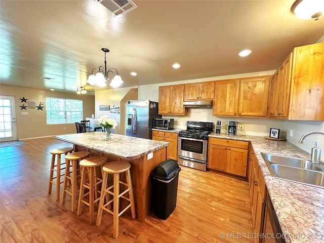 114537 Spring Creek Rd, Eufaula, OK 74432 - kitchen with stainless steel appliances, a sink, under cabinet range hood, light wood-style flooring, and a center island