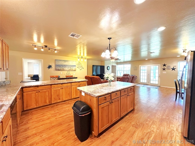 114537 Spring Creek Rd, Eufaula, OK 74432 - kitchen featuring open floor plan, light wood-style flooring, a chandelier, freestanding refrigerator, and light countertops