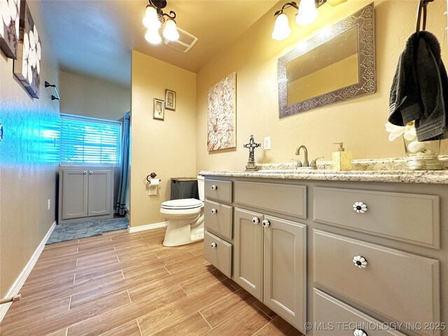 114537 Spring Creek Rd, Eufaula, OK 74432 - bathroom featuring wood finished floors, toilet, vanity, and baseboards