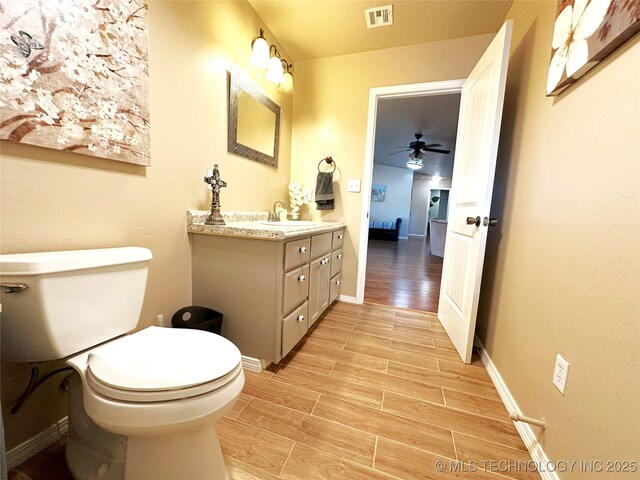 114537 Spring Creek Rd, Eufaula, OK 74432 - bathroom featuring wood finished floors, ceiling fan, vanity, toilet, and baseboards