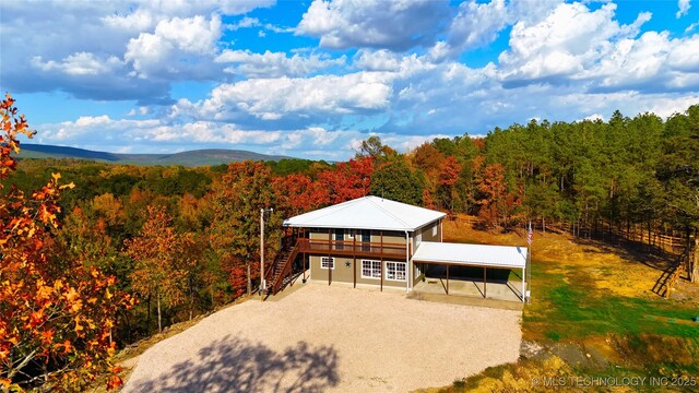 174550 N 4430th Rd N, Nashoba, OK 74558 - view of front of home with a wooded view, stairs, a wooden deck, driveway, and a detached carport