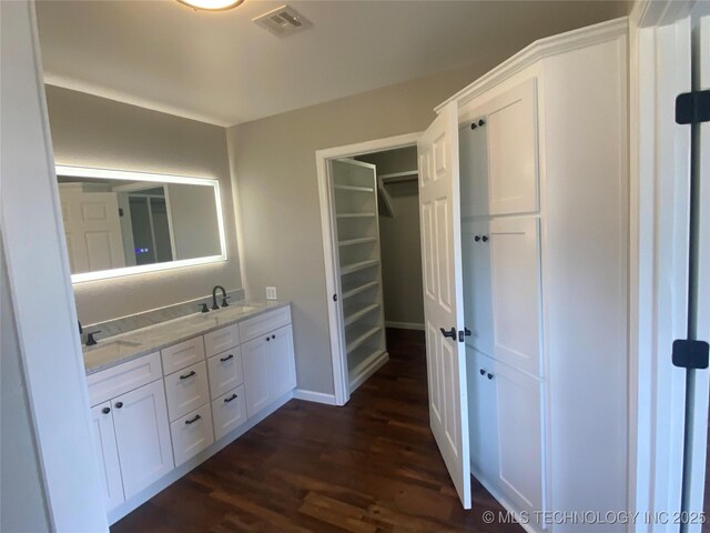 174550 N 4430th Rd N, Nashoba, OK 74558 - bathroom with wood finished floors, double vanity, a walk in closet, and baseboards