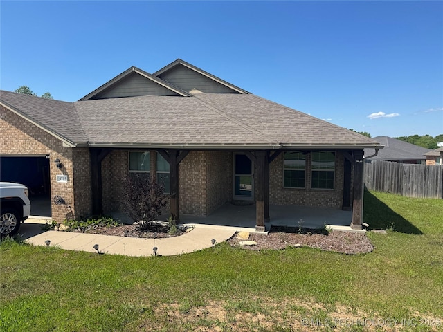 4715 Travertine, Ardmore, OK 73401 - ranch-style home featuring roof with shingles, a garage, brick siding, and a patio area
