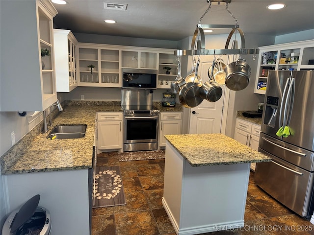 4715 Travertine, Ardmore, OK 73401 - kitchen featuring stainless steel appliances, open shelves, a sink, light stone counters, and dark stone finish flooring