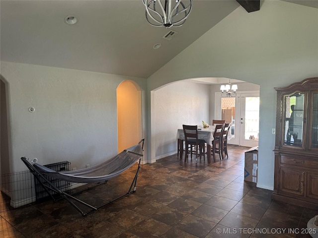 4715 Travertine, Ardmore, OK 73401 - dining space with a chandelier, arched walkways, baseboards, high vaulted ceiling, and dark stone finish floors