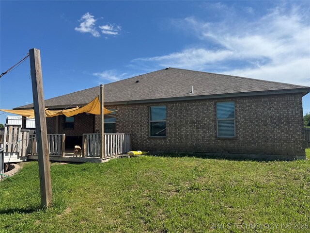4715 Travertine, Ardmore, OK 73401 - back of house with a wooden deck, brick siding, a lawn, and roof with shingles