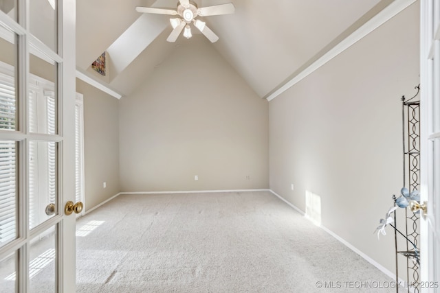 spare room featuring a ceiling fan, carpet flooring, lofted ceiling, and baseboards