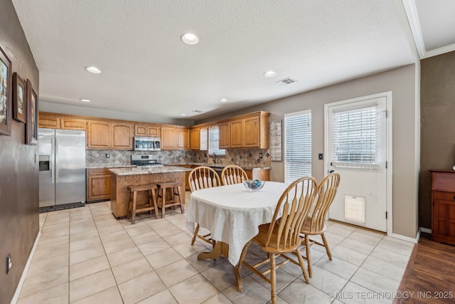 dining area featuring light tile patterned floors, a textured ceiling, recessed lighting, and baseboards