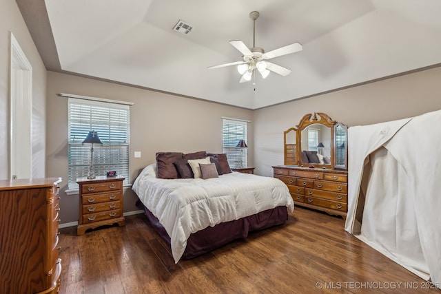 bedroom with dark wood-style floors, vaulted ceiling, and a ceiling fan
