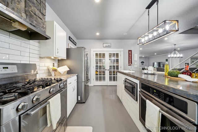 kitchen featuring stainless steel appliances, under cabinet range hood, concrete floors, decorative backsplash, and french doors