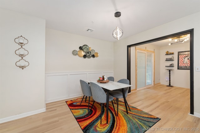 1014 SE 3rd St, Wagoner, OK 74467 - dining room featuring light wood-type flooring, wainscoting, and a chandelier