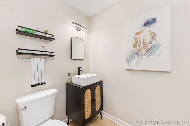 1014 SE 3rd St, Wagoner, OK 74467 - half bath with toilet, baseboards, vanity, and wood finished floors