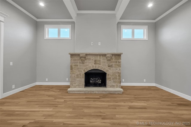 unfurnished living room with wood finished floors, ornamental molding, baseboards, a fireplace with raised hearth, and recessed lighting