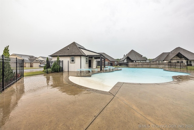 community pool with a patio and fence