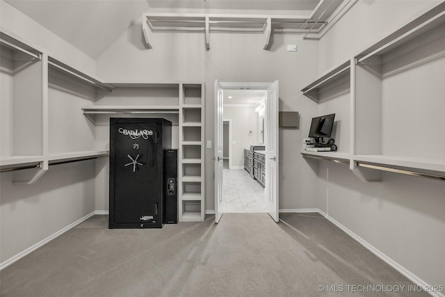 spacious closet with carpet floors and vaulted ceiling