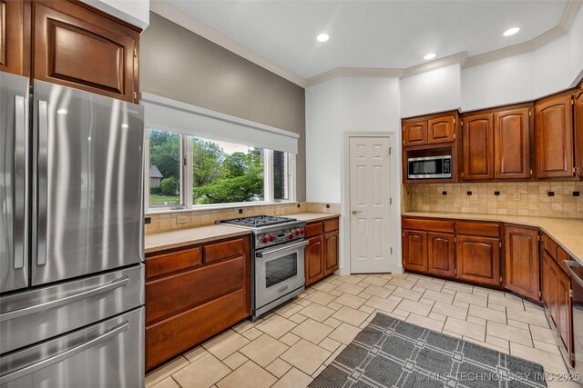 9304 E 113th St S, Bixby, OK 74008 - kitchen featuring stainless steel appliances, light countertops, decorative backsplash, recessed lighting, and brown cabinets